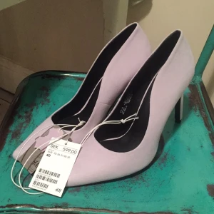  - Höga klackar med spetsig tå från h&m "real suede". Ljusa med en lätt lavendel ton. DM hög klack. Aldrig använda, alla lappar kvar. Funkar på 39-40