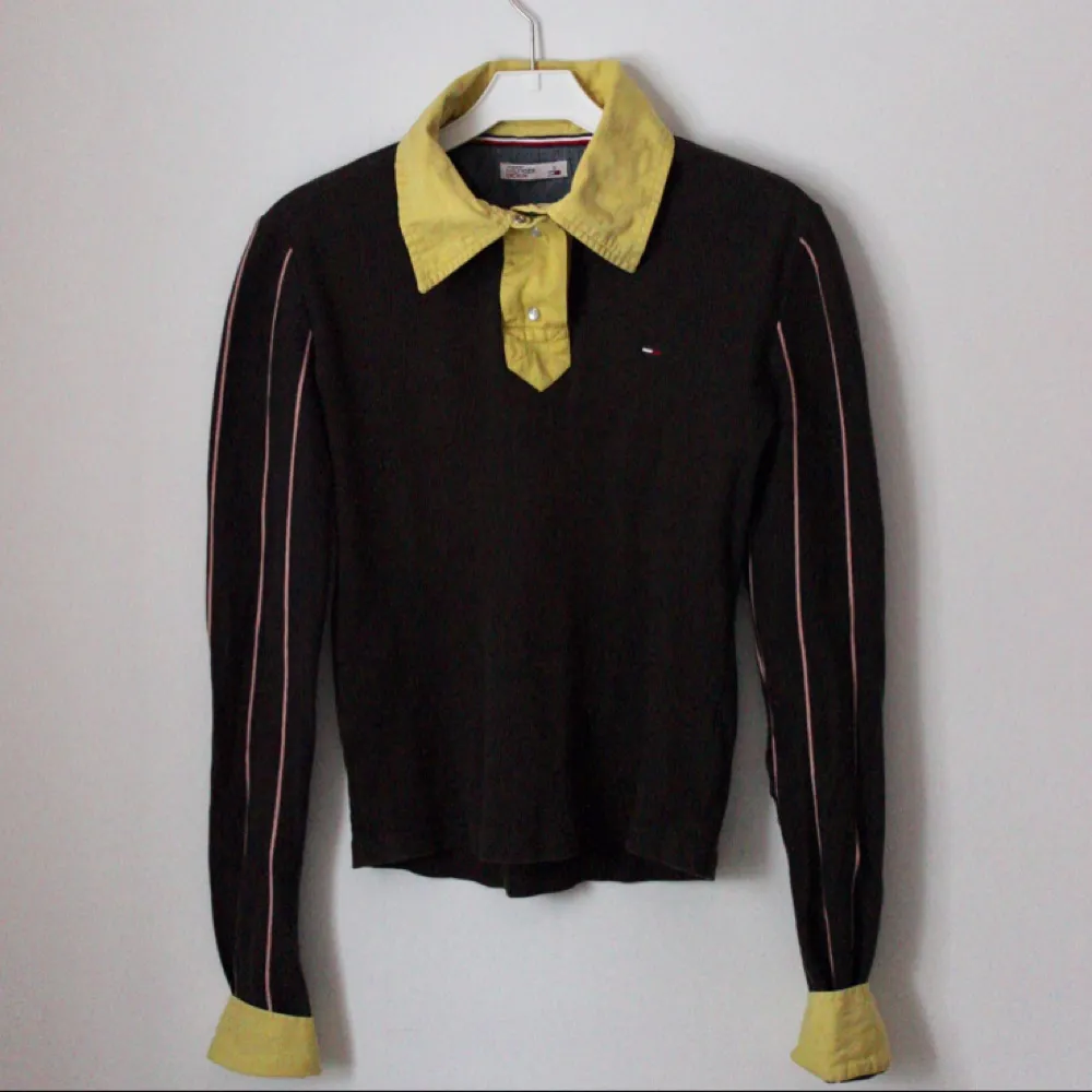 Tommy Hilfiger Denim tröja i retro stil, köpt i en Second Hand butik i Barcelona. Ribbad långärmad tröja med TH loggan på framsidan och baksidan! 
Syns att den är använd men bra skick 🌸. Toppar.