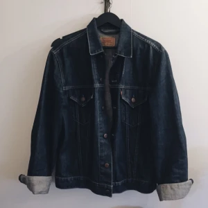  - Levi's klassisk mörkblå jeansjacka. Storlek XL men funkar utmärkt på mig som brukar ha L annars.