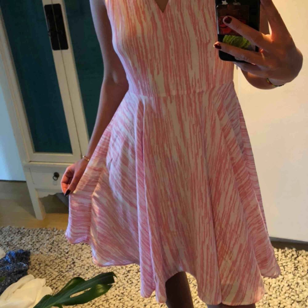 Somrig klänning i vitt och rosa mönster💕  Kort modell med en fin V-ringning både bak och fram. Använd en gång på skolanvslutning💞. Klänningar.