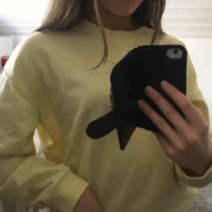  - En ljusgul tröja från H&M med ett litet tryck på ena bröstet. Någorlunda oversized.
