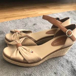 Skor från Tommy Hilfiger   - Beiga skor med kilklack från Tommy Hilfiger. Aldrig använda och i mycket fint skick. Normala i storleken. 