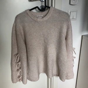 Stickad tröja med knytning - Jätte fin stickad tröja från Zara med knytning i ärmarna. Bra skick. Dåligt ljus på bilden dock. 