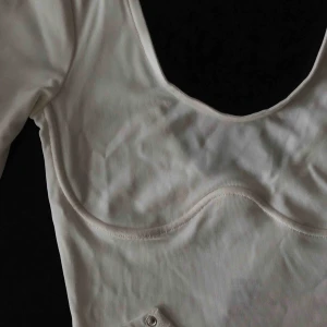  - Ribbad bodysuit med sömmar under bysten, låg fram och bak. Aldrig använd med prislapp kvar! 