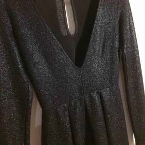  - Svart glittrig jumpsuit från gina tricot. Storlek S. Aldrig använd. Väldigt djup urrigning. Frakt ingår i priset