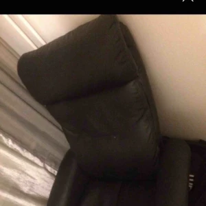  - Fåtölj och fotpall i svart läder i gott skick 