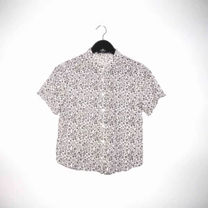  - Vit bas med brunt blommönster. Köpt secondhand men är i gott skick. Det står strl L men det är definitivt max en medium!  