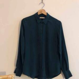 Mörkgrön skjorta med dolda knappar, från Gina Tricots ”Premium Quality”. Skjortan är i 100% silke.  Storlek 38. Nyskick. 