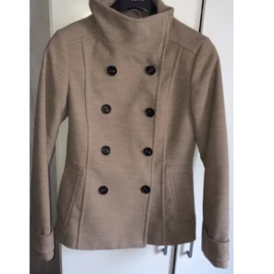  - Snygg kappa i beige färg, köpt på h&m knappt använd är som ny! Storlek 36 