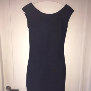  - Svart tight klänning med urringning bak i ryggen 
