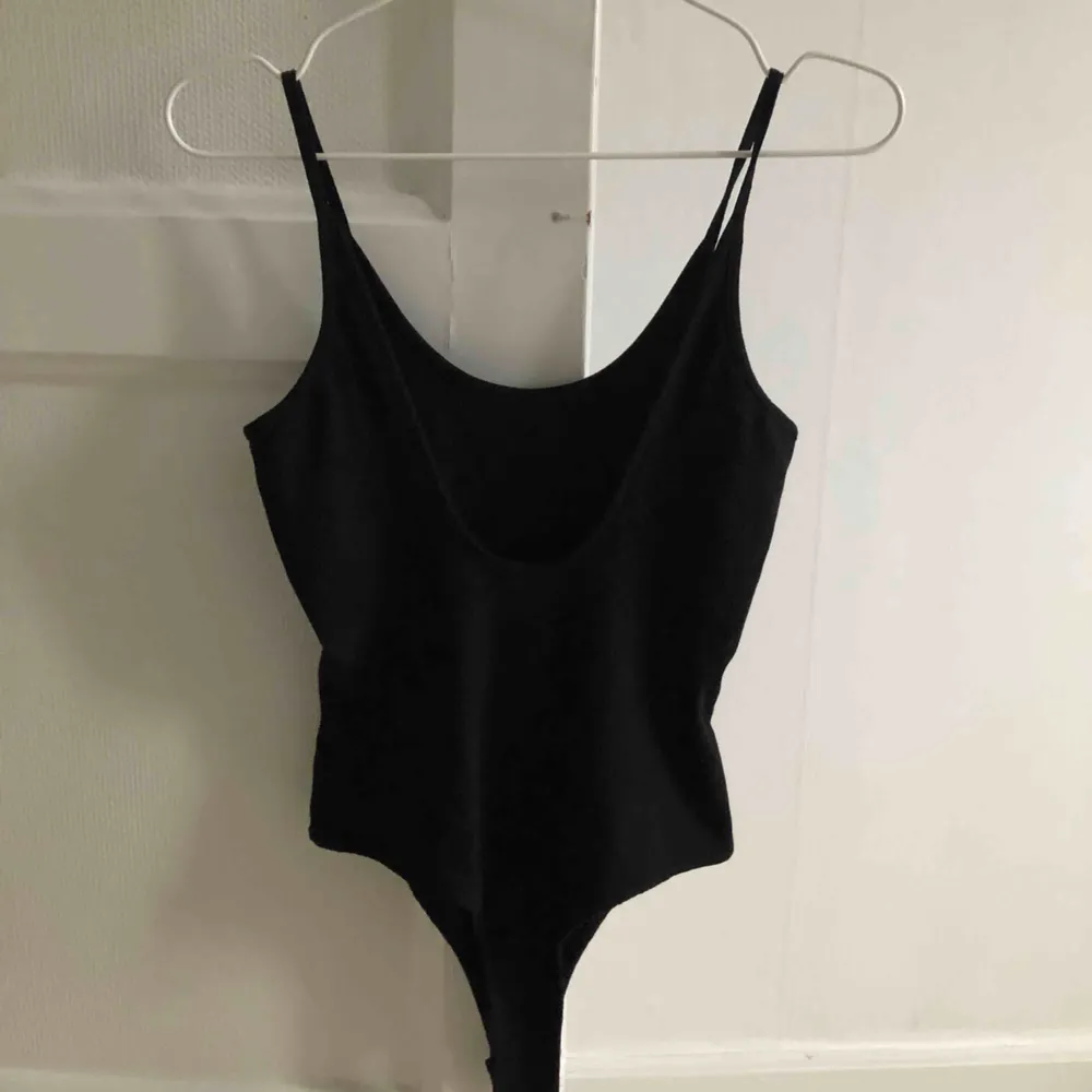 snygg basic svart bodysuit från Ivyrevel. Fin detalj med öppen rygg, perfekt inför sommaren☀️ Använd fåtal gånger. (OBS, pris inkluderar frakt) . Toppar.