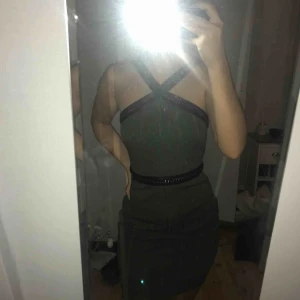  - Mörkgrön klänning från topshop i storlek 36. Med läderdetaljer och en kedja runt bröst och axlar, dragkedja på baksidan. Den sitter jättebra och tight på kroppen. Rumpan får även en fin form + 55kr frakt. Inte fläckig som det ser ut på sista bilden.