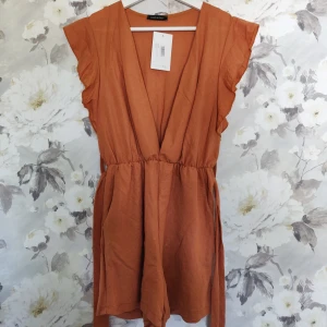 Helt ny playsuit  - Playsuit från boohoo med djup skärning. Lapparna är kvar. Säljes pga för liten för mig. Gratis frakt!