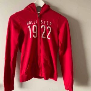  - Röd hoodie från Hollister, välanvänd men i gott skick. Möts upp i Stockholm, men skickar även på posten. Frakten är ej inkluderad.