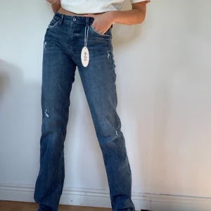 Raka jeans - Säljer dessa jättesnygga jeans, snygg blå färg med lite slitningar och raka ben. Helt oanvända, lappar sitter kvar. Långa på mig som är 172, även lite stora i midjan. Storlek 29/34 och jag brukar ha 27 (28 för få oversize) i midjan. Orginalpris: 499 kr. Köparen står för frakten!💫