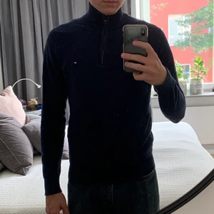 Tommy Hilfiger tröja med hög krage - Tommy Hilfiger stickad tröja i mörkblå färg. I fint skick och använd ett fåtal gånger. Kan skicka över hela Sverige mot fraktkostnad eller mötas upp i Stockholm. Storlek medium(M) men skulle säga att den passar mer som en small(S)
