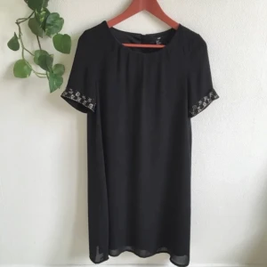 Klänning med pärlor - Svart klänning med fina pärlor på ärmarna och med dragkedja i ryggen. Har en underkjol. Är både snygg och sitter bekvämt 🥳