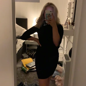 Klänning svart - Hej, nu säljer jag denna fina klänning då den är för liten för mig, haft på mig denna 1-2 gånger och har dragkedja bak som går ända till rumpan. Lite volang i armarna har en krage med ett fint diamant/ pärlor mönster i rosa och silver. Modell tajt, budgivning 💕 kostar extra med frakt men de tar vi då💕