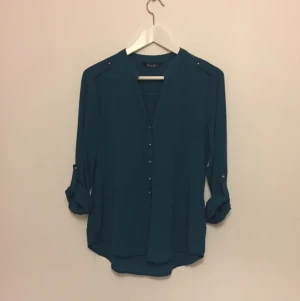  - Mörkgrön blus med gulddetaljer