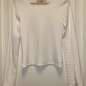 Off-white top med slits - Off-white topp med slits på ärmarna från ivyrevel. Endast använd 1 gång. Köparen står för frakten. 