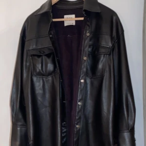 Zara skinn  - Min fina Skjort jacka i fake skinn från zara! Köpt för ett år sedan men kommer tyvärr inte till användning:( tillkommer även ett fint band i midjan på sidan av!  Köparen står för frakt(100kr), HÖGSTA BUD 300 KR, BUDGIVNING slutar idag kl 14:00!