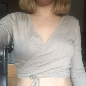  - Tröja som knuts omlott. Endast använd enstaka gånger, därav bra skick. Mjukt material, i en beige nyans. 