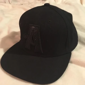  - Knappt använd svart keps. A:et är glittrigt! 