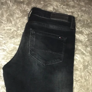  - Tommy Hilfiger jeans i en svart blå färg, endast  testade. Nypris 1199 
