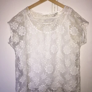  - Blus i vit spets från Stockhlm i mycket gott skick. Strl S men relativt stor i storlek så kan passa en M. Knappt använd.