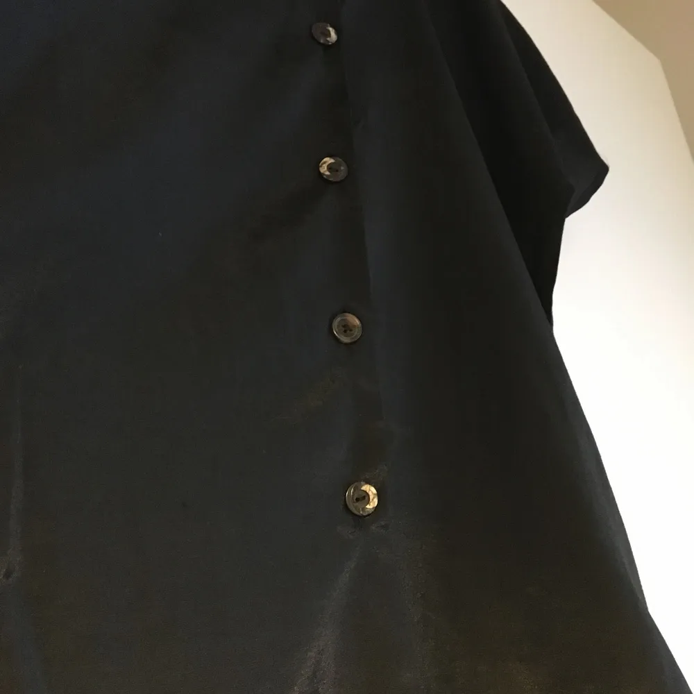 True vintage black satin shirt with natural buttons. Interesting shape arms and flattering cut. . Blusar.