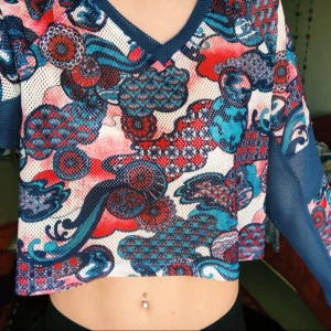  - Magtröja i blå-rött mönster med v-ringning. Nätigt tyg (ej genomskinlig). Aldrig använd! 
