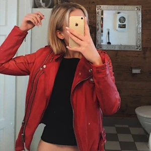  - Röd Jofama by Kenza-jacka i skinn. Storlek 38, men passar även mig som har storlek 36. Jackan är i använt skick och den ena ärmen är något solblekt (se bild 2 & 3), men personligen tycker jag att detta ger jackan en snyggare vintage look. Nypris ca 3000 kr. Köparen står för eventuell frakt.