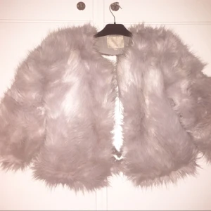  - Superfin ljusgrå fluffig jacka från madlady. Liten i storleken så en M passar bra på en S.  Endast använd en gång på nyår! Kommer dock inte till användning igen därför jag säljer. Nypris: 999:-