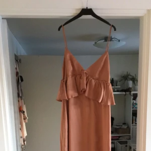  - Knälång klänning i ”siden” material, klänningen är använd en gång och är i fint skick. Frakt tillkommer om det behövs skickas.