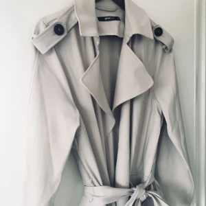  - Trendig trenchcoat i storlek 38 använd 1 gång . ( frakt tillkommer om du ej vill hämta)