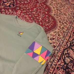  - Mysig tjocktröja i blå/grön, massa färger på armarna 😍