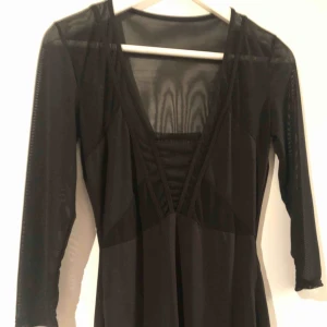  - Klänning som slutar strax över knäna  Genomskinlig upptill men vanligt tyg ner  Aldrig använd då den i passa min kropp.  Djupurigning 