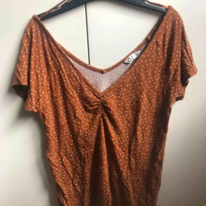  - En rostfärgad prickig T-shirt med offshoulder känsla. Säljer så den inte kommer till användning.  Pris: 50kr, frakt tillkommer! Hör av dig vid frågor💕