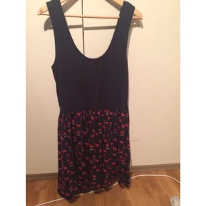  - Marinblå klänning med dragkedja i ryggen med hästmönster på kjol delen. 
Använd 2 gånger.

OBS! Ska plagget fraktas står köparen för den här kostnaden
