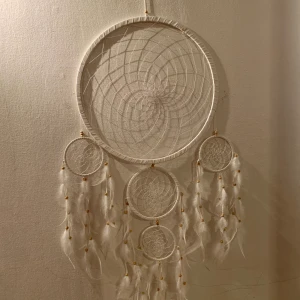 Stor drömfångare - Kritvit drömfångare med träpärlor. Den är runt 1,5 meter på längden och 50cm på bredden. Jättefin att ha på väggen över sängen. Den är värkligen som ny och har hängt på samma ställe i mitt rum i ca ett år. Den har gjort att jag drömt massor av fina drömmar😉! 
