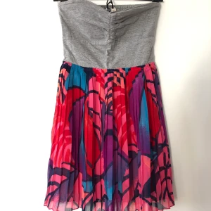 Klänning från Roxy i storlek S  - Klänning från Roxy. Överdel är grått tshirt-tyg i stretch á la smock i ryggen (se bild). Och underdelen är veckad och mönstrad. Finns insydd underkjol. Använd 2 gånger. 