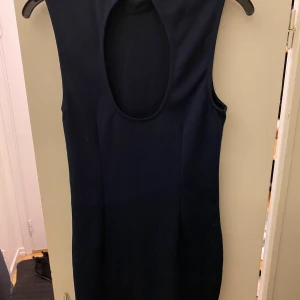 Klänning med djup i ryggen - Mörkblå kort klänning från Bik Bok, snyggt djup i ryggen. 