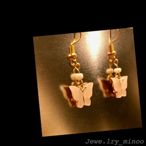 Guldörhängen vit fjäril  - ♡Fjärilsörhängen♡ (emalj, vit) bild två gör färgen mäst rättvisa! De är inte rosa💗 kolla in mina andra smycken! Frakten blir 12kr hur mkt du än köper!