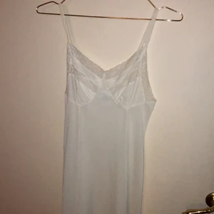 Vit ”nattlinne”  - Vit med spetts har tunna band. Skriv om frågor