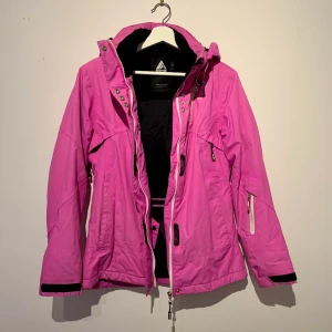 Skidjacka/ 8848 Altitude/ Nyskick - Skidjacka från 8848 Altitude. Använd 3 gånger, som ny! Köpt för 2 200 kronor på Intersport. St 38, men passar även 36. Snölås i midja, ställbar och avtagbar huva, krage med fodrad fleece. Justerbara ärmavslut med kardborre. Vindtät och vattenavvisande!