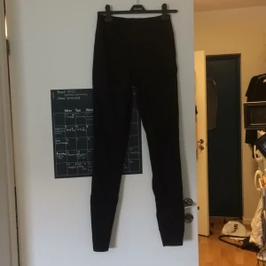  - Svarta jeans som är höga i midjan med dragkedja baktill. Bra passform med stretch i sig.
