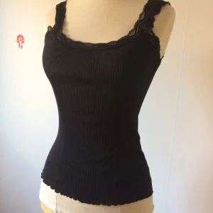  - Svart linne med enkla spetsdetaljer. Plagget är i 55% silke, 45% bomull vilket gör att det andas 