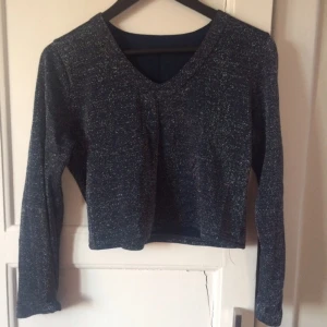  - Glittrig, mörkblå croptop som går att anpassa! Antingen en V-ringning vid halsen eller en hög rak skurning. 