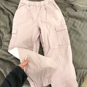 Rosa cargopants strl 38 - Rosa cargopants från HM, aldrig använda, toppskick! Färgen framgår otydligt på bilderna, i verkligen är byxorna pastellila/smuts-rosa. 