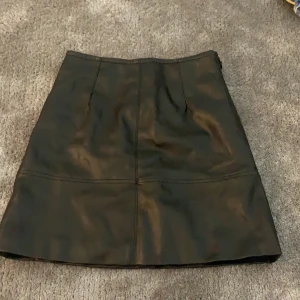 Skinnkjol från H&M storlek 34 - Aldrig använd kjol från H&M i storlek 34, säljer pga har andra skinnkjolar jag redan använder!!